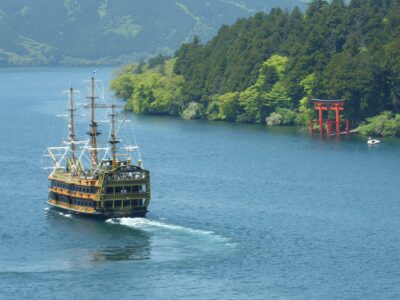 緑の湖畔と赤い鳥居、観光船