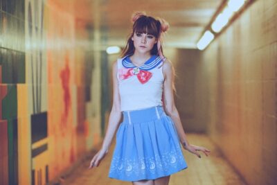 青い衣装と赤いリボンを着けたコスプレ姿の女性