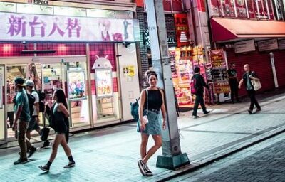 看板が並ぶ街の通りを歩く人々