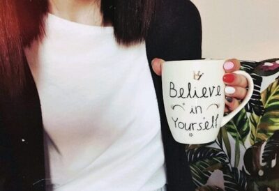 Believeの文字が入ったマグカップを持つ女性