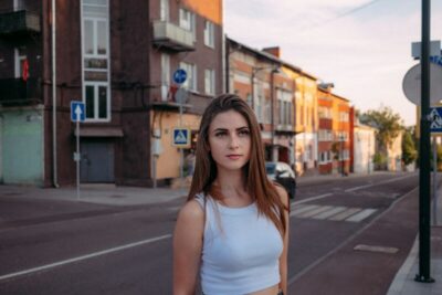街角に立つ白いノースリーブの女性